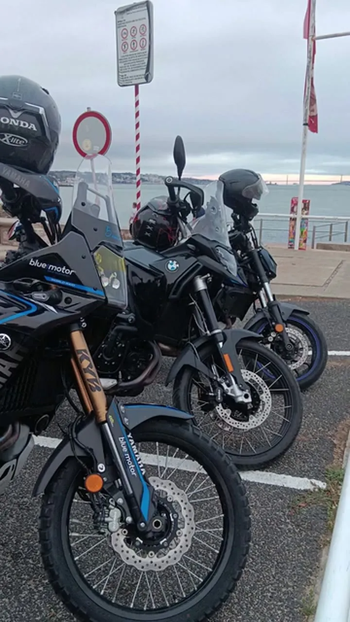 Motas de aventura estacionadas junto ao rio